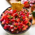 Bowl of easy strawberry jalapeño salsa with fresh ingredients