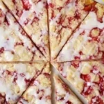 Gluten-free raspberry crumble dessert pizza topped with fresh raspberries