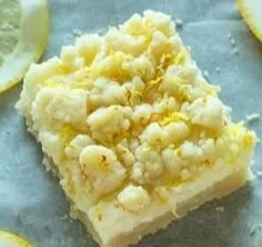Lemon sugar cookie bars topped with a light glaze and garnished with lemon zest