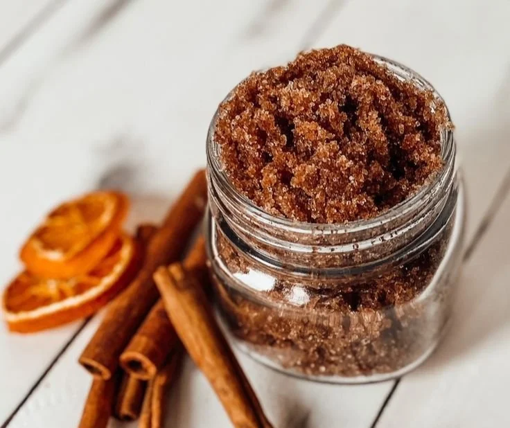 Orange Spiced Sugar Scrub in a jar with orange slices and spices around it.
