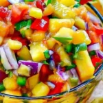 Delicious homemade peach salsa served in a bowl with tortilla chips.