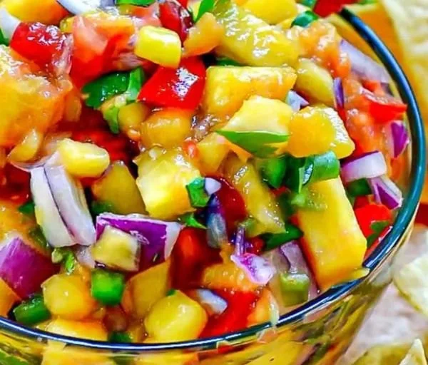 Delicious homemade peach salsa served in a bowl with tortilla chips.