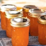 Jar of homemade peach zucchini jam on a wooden table