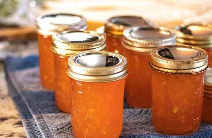 Jar of homemade peach zucchini jam on a wooden table