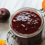 Homemade slow cooker plum butter jar on kitchen counter