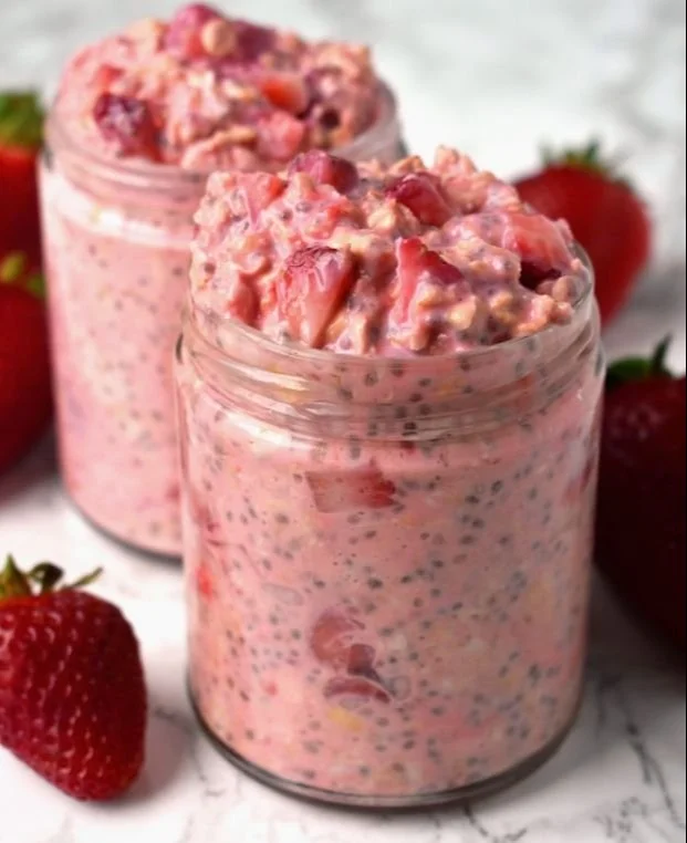 Bowl of strawberries and cream overnight oats topped with fresh strawberries