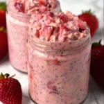 Bowl of strawberries and cream overnight oats topped with fresh strawberries