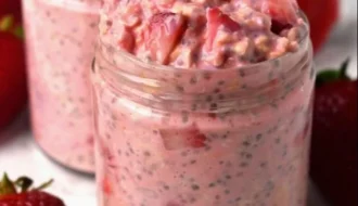 Bowl of strawberries and cream overnight oats topped with fresh strawberries