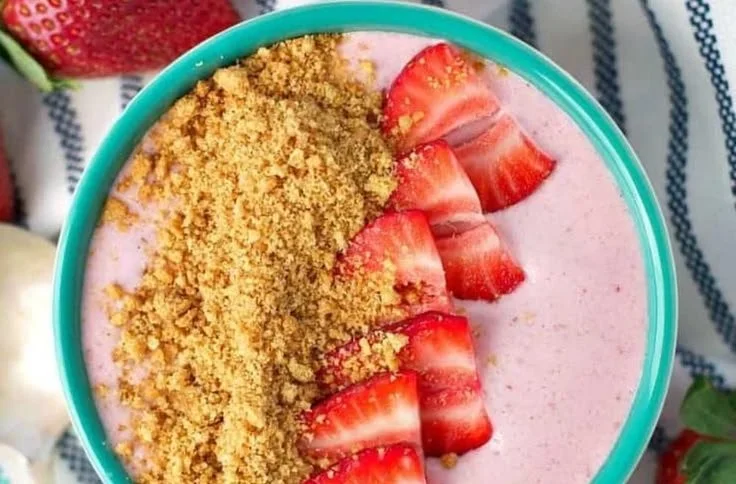 Delicious Strawberry Cheesecake Smoothie Bowl topped with fresh strawberries and granola
