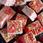Strawberry Shortcake Rice Krispie Treats displayed on a plate with fresh strawberries