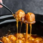 Slow cooker enchilada meatballs served with cheese and garnished with cilantro