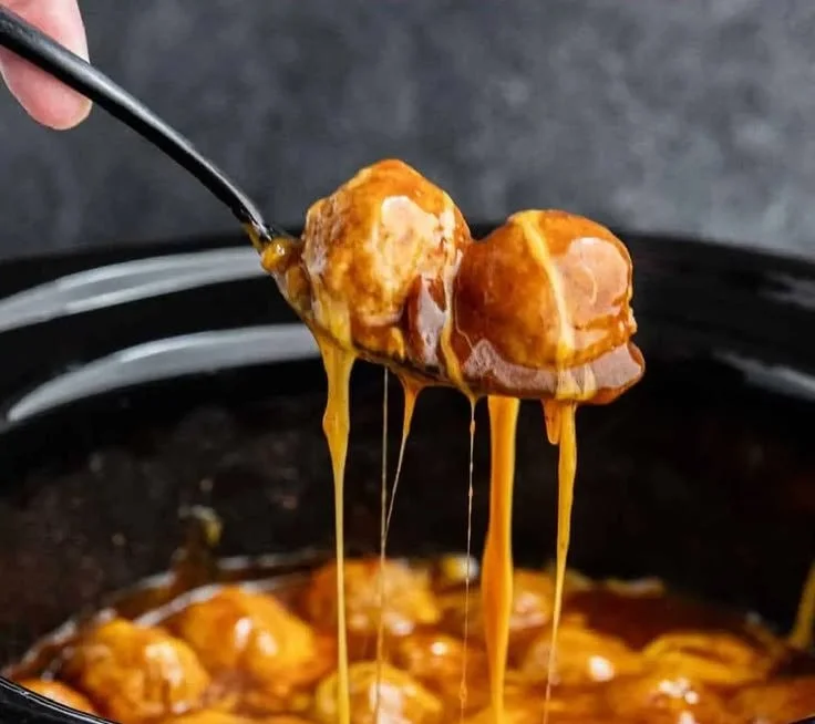 Slow cooker enchilada meatballs served with cheese and garnished with cilantro