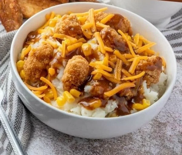 A delicious bowl of homemade Copycat KFC Bowls with layers of chicken, corn, and mashed potatoes.