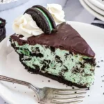 A vibrant slice of Grasshopper Pie topped with mint and chocolate garnish.