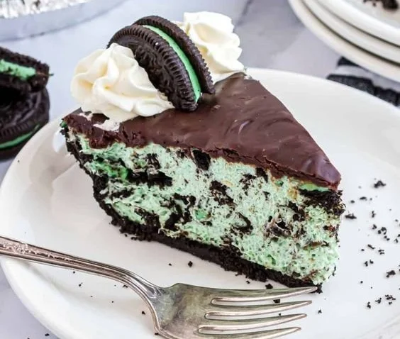 A vibrant slice of Grasshopper Pie topped with mint and chocolate garnish.