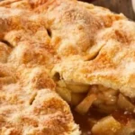 Slice of homemade apple pie on plate with fork