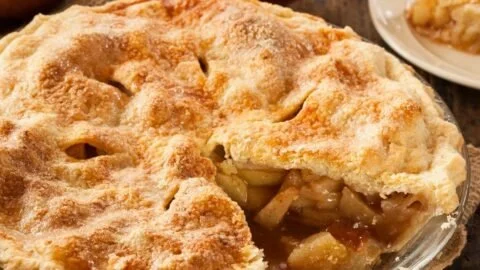 Slice of homemade apple pie on plate with fork