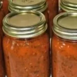 Bowl of homemade pizza sauce with fresh herbs and tomatoes