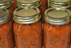 Bowl of homemade pizza sauce with fresh herbs and tomatoes