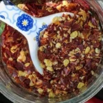 Homemade red pepper flakes and cayenne powder in small glass jars