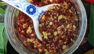 Homemade red pepper flakes and cayenne powder in small glass jars