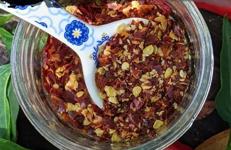 Homemade red pepper flakes and cayenne powder in small glass jars
