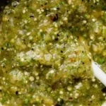 A bowl of roasted salsa verde served as a party dip with tortilla chips.