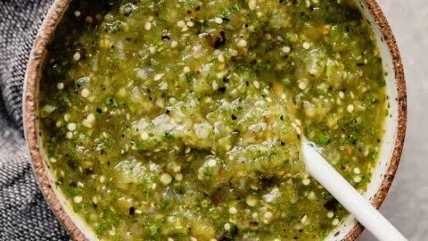 A bowl of roasted salsa verde served as a party dip with tortilla chips.
