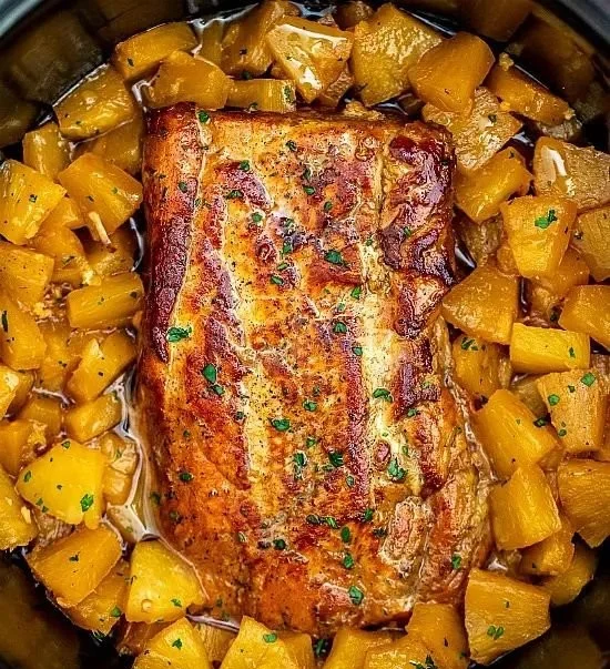 Delicious slow-cooked pineapple pork loin on a plate with herbs