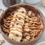 Delicious Snickers smoothie bowl topped with chocolate and nuts