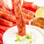 Spicy watermelon fries served in a bowl with a dipping sauce