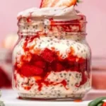 Delicious bowl of strawberries and cream overnight oats topped with fresh strawberries