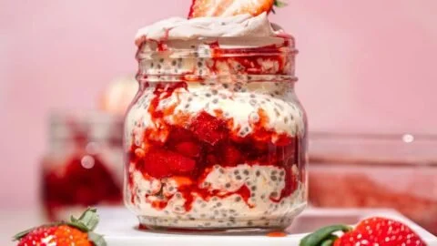 Delicious bowl of strawberries and cream overnight oats topped with fresh strawberries
