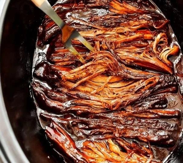 Deliciously tender BBQ brisket served with sides at a cookout.